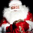 Santa sitting at the Christmas room and looking into the sack
