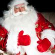 Santa sitting with a sack indoor at dark night room