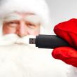 Traditional Santa Claus holding 3g usb modem in his arm on foreg
