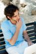 Portrait of a young man with laptop outdoor sitting on bench