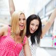 Closeup of two attractive happy girls out shopping