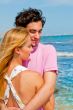 Portrait of young couple in love embracing at beach and enjoying
