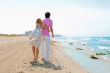 Couple at the beach holding hands and walking. Sunny day, bright