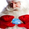 Traditional Santa Claus holding and sowing credit card while giv
