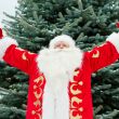 Portrait of Santa Claus standing with open hands outdoors at chr