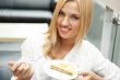 Portrait of young pretty smiling woman eating cake at shopping m