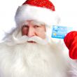 Traditional Santa Claus holding and sowing credit card while giv