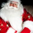 Santa sitting with a sack indoor at dark night room