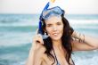Young hispanic woman with wet skin and with a snorkel standing o