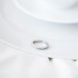 Closeup photo of proposal ring on white plate of coffee cup and 