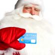 Traditional Santa Claus holding and sowing credit card while giv