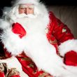 Santa sitting with a sack indoor at dark night room