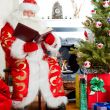 Santa sitting at the Christmas tree, fireplace and reading a boo