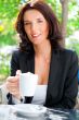 Portrait of pretty young business woman sitting relaxed at outdo