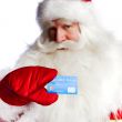Traditional Santa Claus holding and sowing credit card while giv