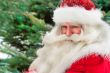 Santa Claus portrait smiling against christmas tree outdoor in s