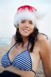 Young beautiful woman wearing christmas hat showing heart shape 