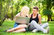 Young happy smiling couple with laptop at picnic