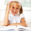 Portrait of a young girl in school at the desk.