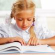 Portrait of a young girl in school at the desk.