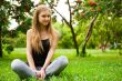 Beautiful female student outdoors sitting on grass at campus par