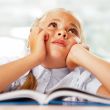 Portrait of a young girl in school at the desk.