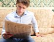 Closeup portrait of young man with newspaper 