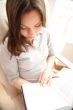 Portrait of a happy young brunette woman holding book