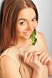 Portrait of young pretty woman holding green leave