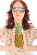 Closeup portrait of woman in sunglasses holding pineapple in her