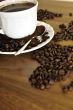 Dramatic photo of world map made of coffee beans. White cup with