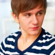 Portrait of young man inside shopping mall sitting relaxed on co