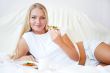 Woman having breakfast in bed. Healthy continental breakfast. Ca