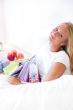 Young happy attractive girl unpack shopping bags in bedroom or h