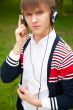 Student listening language course in headphones outside school