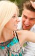 Romantic young couple sitting together in forest and smiling