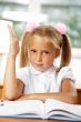 Portrait of a young girl in school at the desk.