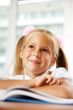 Portrait of a young girl in school at the desk.