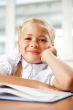 Portrait of a young girl in school at the desk.