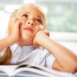 Portrait of a young girl in school at the desk.