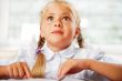 Portrait of a young girl in school at the desk.