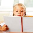 Image of smart child reading interesting book in classroom. Hori
