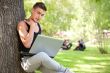 Closeup portrait of young student man leaning on tree trunk 