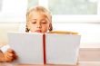 Image of smart child reading interesting book in classroom. Hori