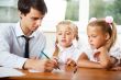 Teacher helping elementary school pupils with their tasks