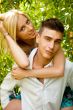 Young couple playing around in the nature - front view. Against 