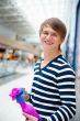 Portrait of young man inside shopping mall standing relaxed and 