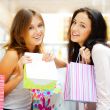 Two excited shopping woman together inside shopping mall. Horizo