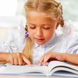 Portrait of a young girl in school at the desk.