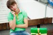 Portrait of young man inside shopping mall with gift box sitting